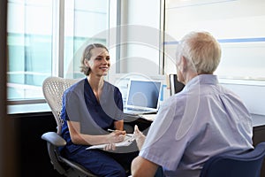 Doctor In Consultation With Male Patient In Office