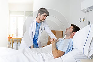 Doctor consulting patient lying on hospital bed talking worried giving bad news about the diagnose photo