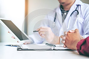 Doctor consulting with patient presenting results on digital tab photo