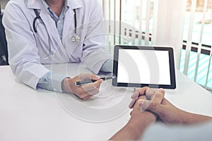 Doctor consulting patient and recommend treatment methods and how to rehabilitate the body, presenting results on tablet computer