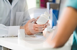 Doctor consulting patient about right medication. Physician holding medicine and pills in hand. photo