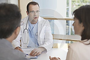 Doctor In Conversation With A Couple At Desk
