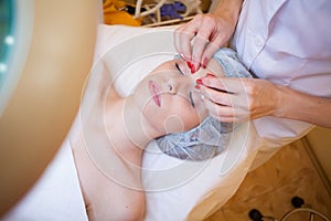 Doctor cosmetologist doing facial massage girl spa