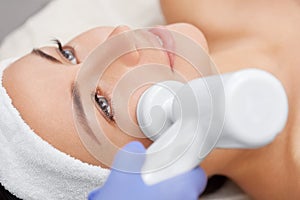 The doctor-cosmetologist makes the apparatus a procedure of Hardware face cleaning with a soft rotating brush photo