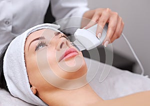 The doctor-cosmetologist makes the apparatus a procedure of ultrasound cleaning