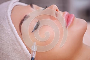 The doctor cosmetologist makes the Botulinotoxin injection procedure for tightening and smoothing wrinkles on the face