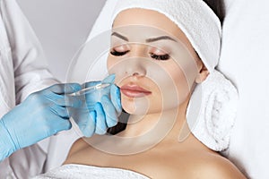 The doctor cosmetologist makes Lip augmentation procedure of a beautiful woman in a beauty salon.Cosmetology skin care