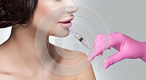 The doctor cosmetologist makes Lip augmentation procedure of a beautiful woman in a beauty salon.Cosmetology skin care