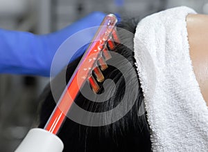 The doctor-cosmetologist makes the procedure Microcurrent therapy On the hair