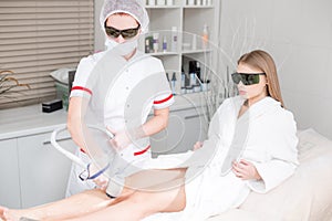 Doctor cosmetologist makes the procedure a young girl blonde. Laser epilation and cosmetology. Hair removal on ladies