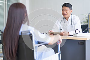 Doctor is counseling female patients on wheelchair