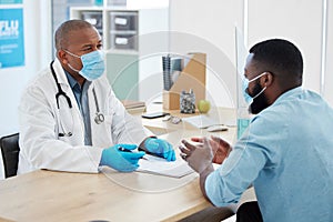 Doctor, covid consultation and black man talking with patient for checkup or results in clinic. Healthcare, medical