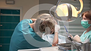 Doctor dentist and assistant working with patient in dental clinic