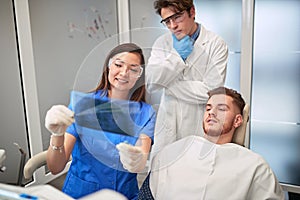 Doctor dentist showing patient`s teeth on X-ray