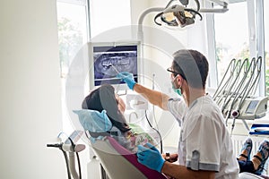 Doctor dentist showing patient`s teeth on X-ray