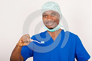 Doctor dentist smiling man holding and showing a toothbrush