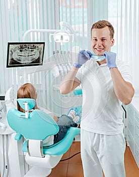 Doctor dentist smiling without medical mask in dental clinic on backdrop with medical equipment, x-ray dental and patient. Smile