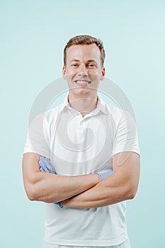 Doctor dentist smiling and standing with hands crossed on light blue background. Smile healthy teeth concept