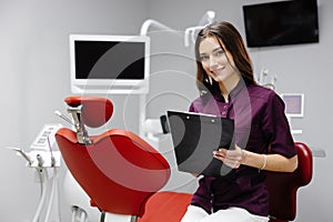 Doctor dentist working in office, using clipboard and making notes