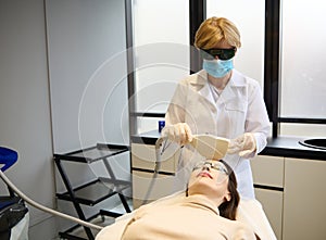 Doctor dermatologist cosmetologist giving facial laser therapy for hair removal, skin smoothing and age spots treatment on patient