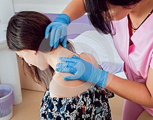 Doctor dermatologist examines birthmark of patient. Checking benign moles
