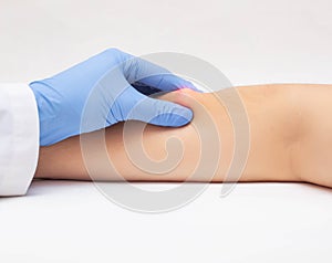 Doctor dermatologist examines the subcutaneous wen on the patient`s arm, close-up. The concept of skin diseases, lipoma