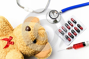 Doctor desk with medical equipment and brown teddy bear.