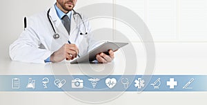 Doctor at desk office write on digital tablet, with symbols and medical icons, web banner and copy space