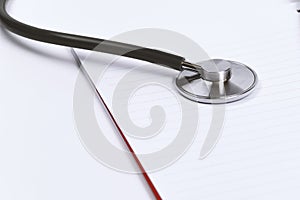 Doctor desk.Stethoscope and notebook on white background