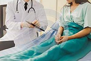 Doctor diagnoses a female patient during treatment at a hospital.