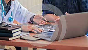  The doctor is diagnosing the tumor picture or cancer from the x-ray film of the patient`s brain in order to plan