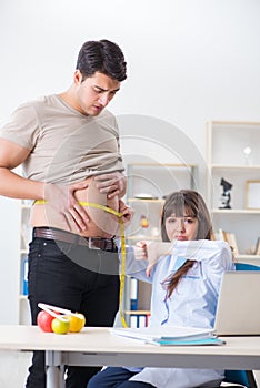 The doctor dietician giving advices to fat overweight patient