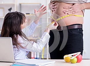 Doctor dietician giving advices to fat overweight patient