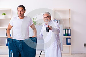 Doctor dietician and happy patient wearing large trousers
