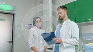 A doctor discusses the patient's medical record with a beautiful nurse.