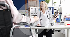 Doctor discusses an x-ray with patient in wheelchair