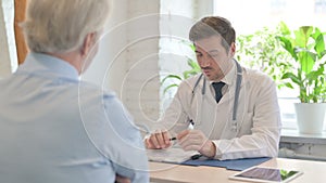 Doctor Discussing Medical report with Old Patient