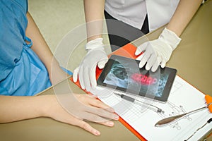 Doctor Discussing Records With Patient Using Digital Tablet PC