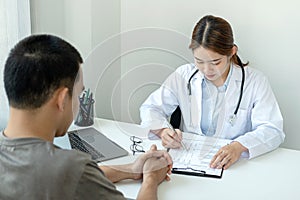 Doctor discussing to explaining disease and symptoms of patient during to writing diagnostic, prescription