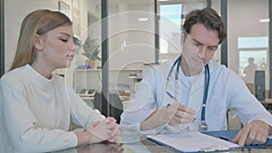 Doctor Discussing Treatment Plan with Young Woman, Writing Medicine