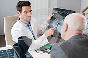 Doctor discussing xray with senior male patient