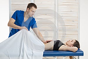 The doctor does diagnostics of muscles of an abdominal cavity of the patient. Removal of tension of muscles of a stomach