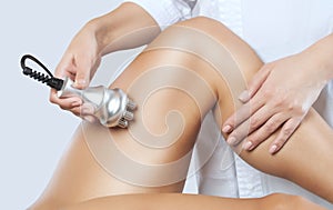 The doctor does the Rf lifting procedure on the legs, buttocks and hips of a woman in a beauty parlor. Treatment of overweight and