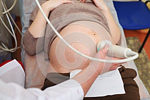 the doctor does an ultrasound examination of the fetus of a pregnant woman in a modern clinic.