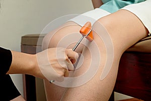Doctor doing examining knee reflex test on patient`s knee,neurol