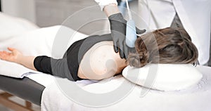 Doctor doing magnetic therapy on male knee