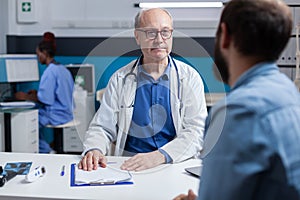Doctor doing medical consultation with patient in cabinet