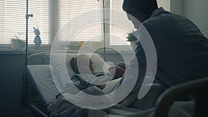 Doctor doing medical examination of sick child modern pediatric hospital ward.