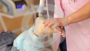 Doctor doing shock wave therapy on heel for a girl