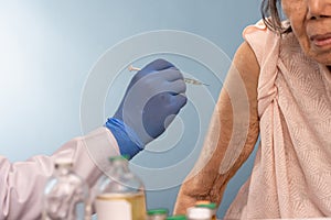 Doctor doing vaccine injection to senior woman